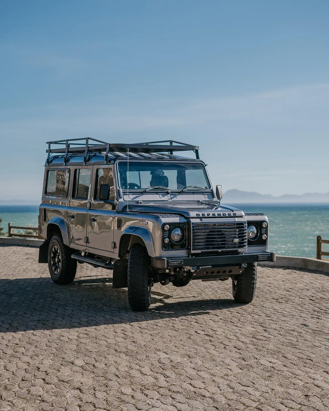 Finished silver Land Rover Defender parked by the sea