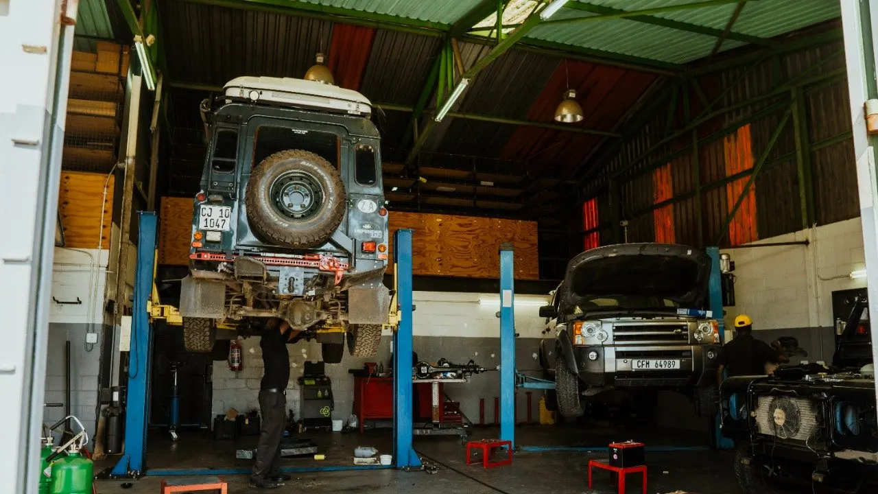 Land Rover Defenders on lifts in our South African partner workshop
