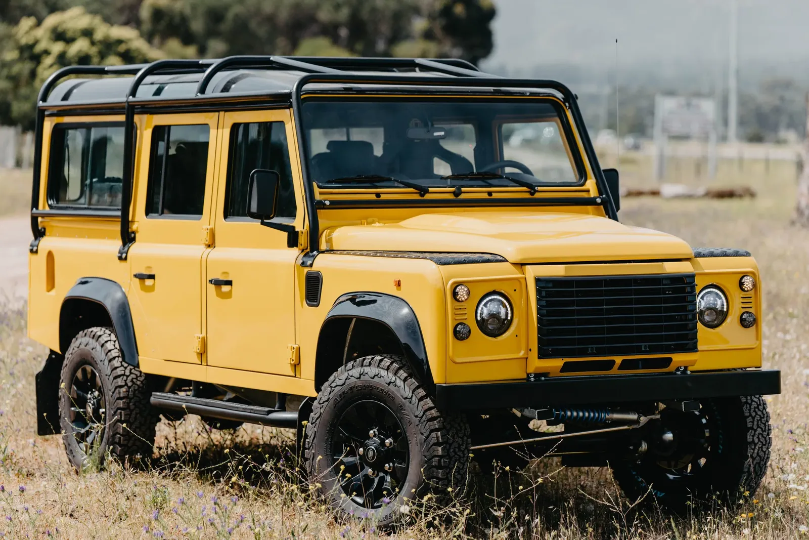 Yellow Land Rover Defender 90 with black wheels, restored by our South African partner workshop