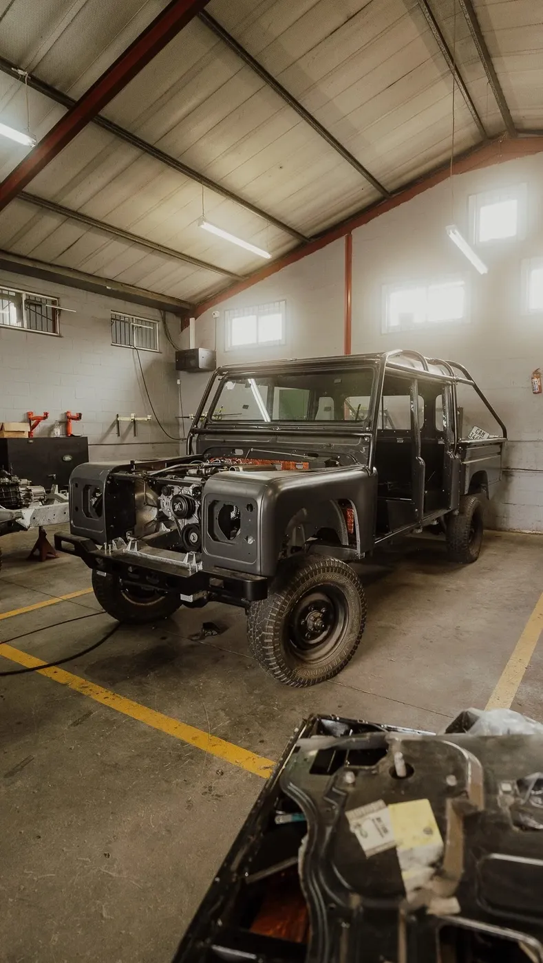 Land Rover Defender body in bare metal mid-restoration in the workshop